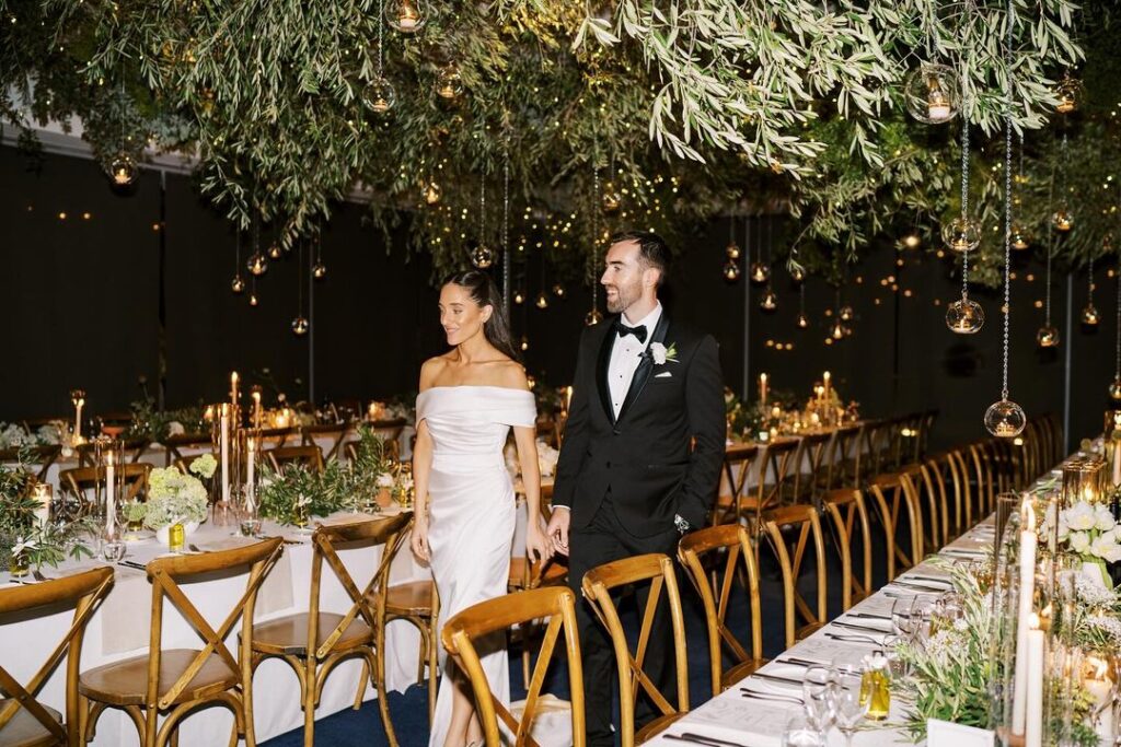 Bride and groom walking through their winter wedding tables