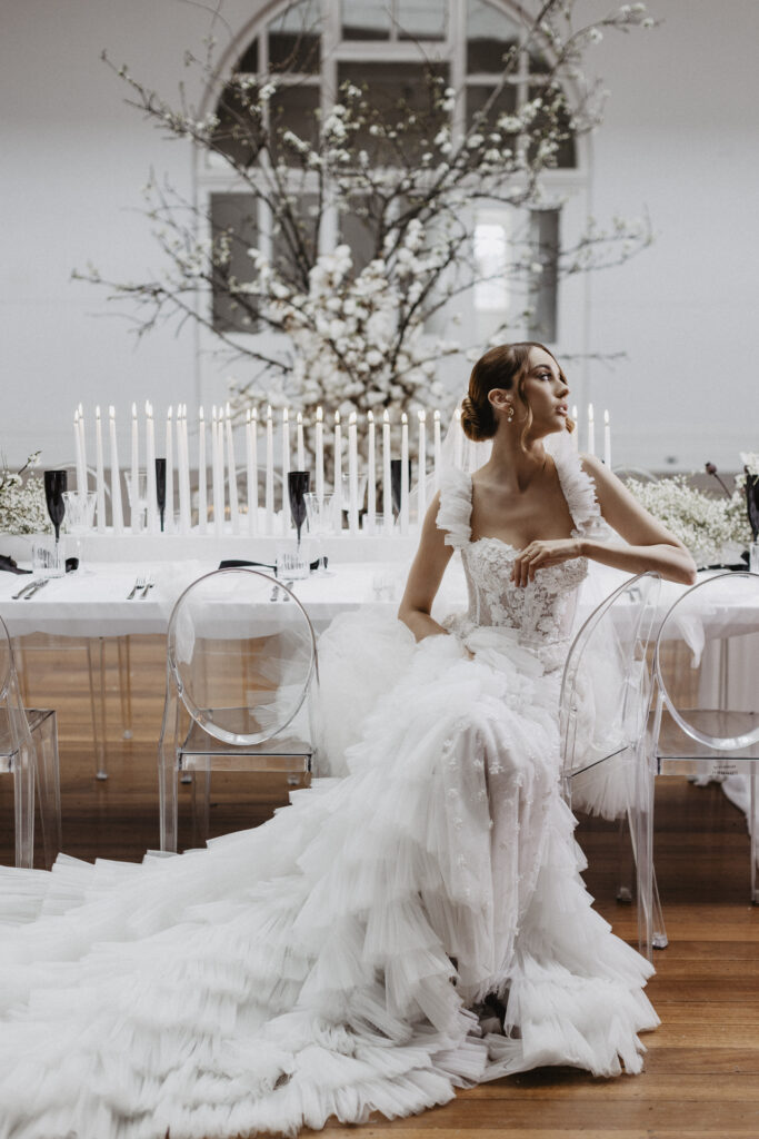 Bride sitting at the table of her white and glamourous themed winter wedding 