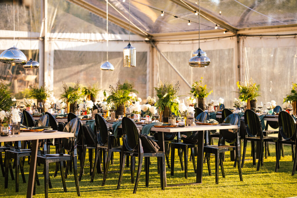 Table setting for outdoor corporate event featuring black chairs